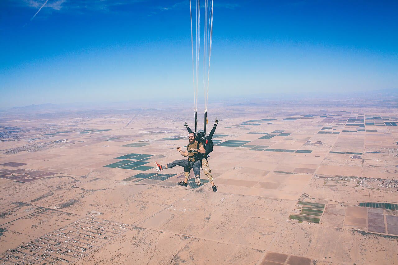 Tandem skydivers over desert